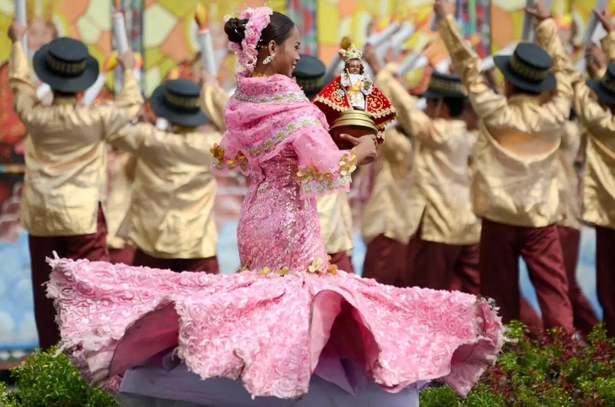 A-Woman-in-a-Pink-Dress-Carrying-an-Image-of-the-Santo-Niño