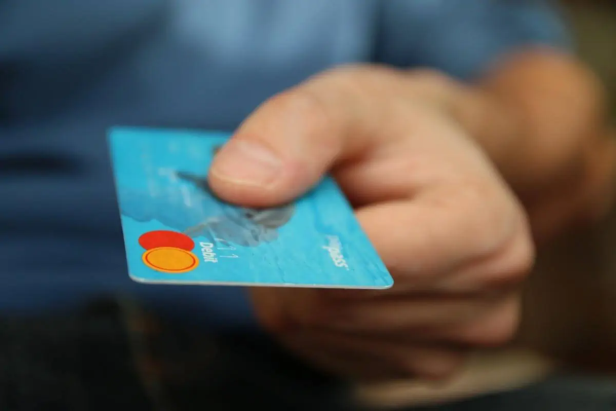 Person-Holding-Debit-Card